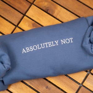 May include: A blue sweatshirt with the text "ABSOLUTELY NOT" printed in white on the front.