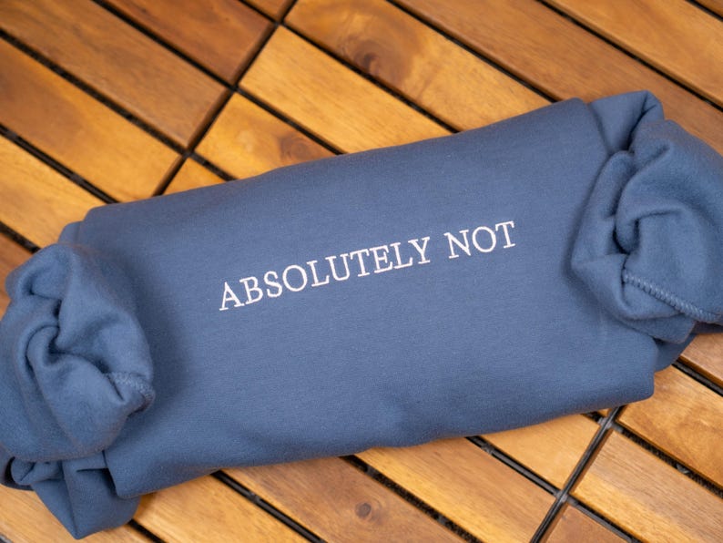 May include: A blue sweatshirt with the text "ABSOLUTELY NOT" printed in white on the front.