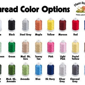 May include: A chart of thread colors for embroidery, with 24 spools of thread in various colors, including white, black, steel grey, maple, yellow, maroon, red, bright navy, mint green, green, medium dark ecru, tawny tan, pink, light pink, pastel yellow, brown, forest green, medium dark avocado, avocado, blue, dark navy, silver grey, charcoal grey, and baby blue. The chart is titled "Thread Color Options" and has a small logo in the top right corner that says "Plant Stitch made with love."