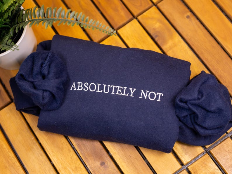 May include: A navy blue sweatshirt with the text "ABSOLUTELY NOT" embroidered in white.