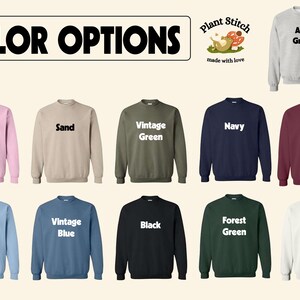 May include: A selection of 10 crewneck sweatshirts in various colors, including light pink, sand, vintage green, navy, maroon, light blue, vintage blue, black, forest green, and white. Each sweatshirt features the text "Plant Stitch" and "made with love" in white lettering. The text "Ash Gray" is displayed on a gray sweatshirt.
