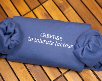 May include: A blue sweatshirt with the text "I REFUSE to tolerate lactose" embroidered in white.