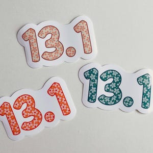 Puede incluir: Tres pegatinas con el texto "13.1". Los n&uacute;meros est&aacute;n rellenos con estampados florales en naranja, coral y turquesa. Las pegatinas tienen un borde blanco y est&aacute;n sobre un fondo blanco.