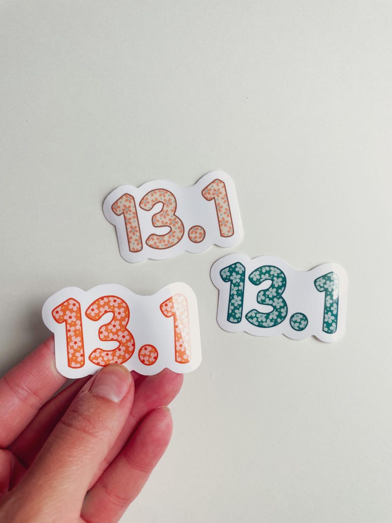 Puede incluir: Tres pegatinas con el texto "13.1". Cada pegatina tiene un borde blanco y un estampado floral dentro de los n&uacute;meros. Una pegatina tiene flores naranjas y melocot&oacute;n, otra tiene flores melocot&oacute;n y la &uacute;ltima tiene flores turquesas.