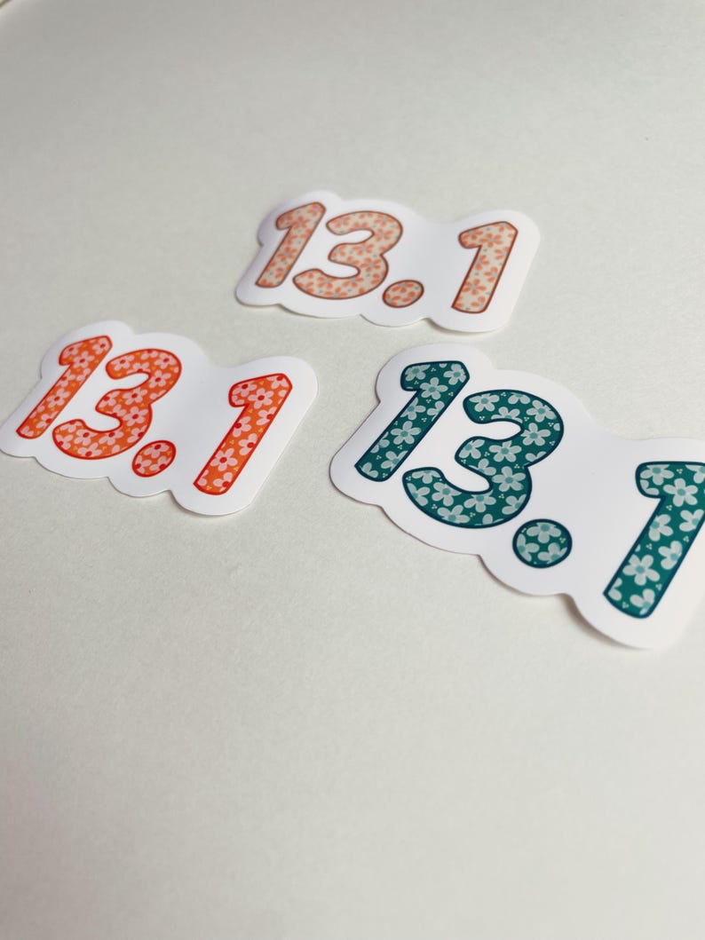 Puede incluir: Tres pegatinas con el n&uacute;mero "13.1" en una fuente redondeada. Las pegatinas son blancas con un estampado floral en naranja, coral y verde azulado. Los n&uacute;meros est&aacute;n delineados en un tono m&aacute;s oscuro del mismo color.