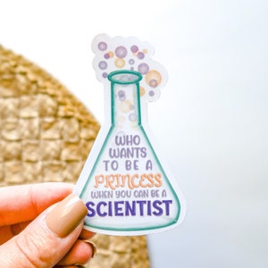 May include: A white sticker with a cartoon beaker with purple and yellow bubbles. The beaker has the text "Who wants to be a princess when you can be a scientist" in purple and teal text.