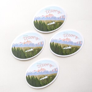 Pode incluir: Quatro adesivos ovais com uma cordilheira e um rio em primeiro plano. O texto "GRAND TETONS WY" est&aacute; escrito em it&aacute;lico em cada adesivo.