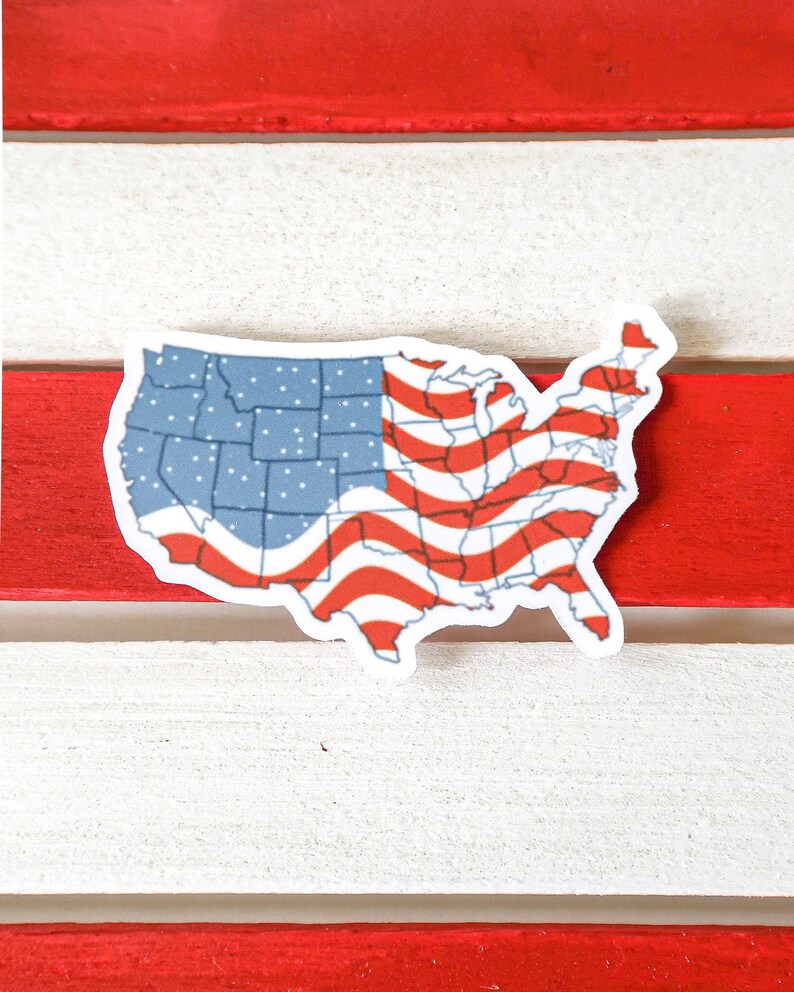 K&ouml;nnte beinhalten: Ein Aufkleber der Vereinigten Staaten von Amerika in Form des Landes mit dem Design der amerikanischen Flagge. Der Aufkleber befindet sich auf einem rot-wei&szlig; gestreiften Hintergrund.