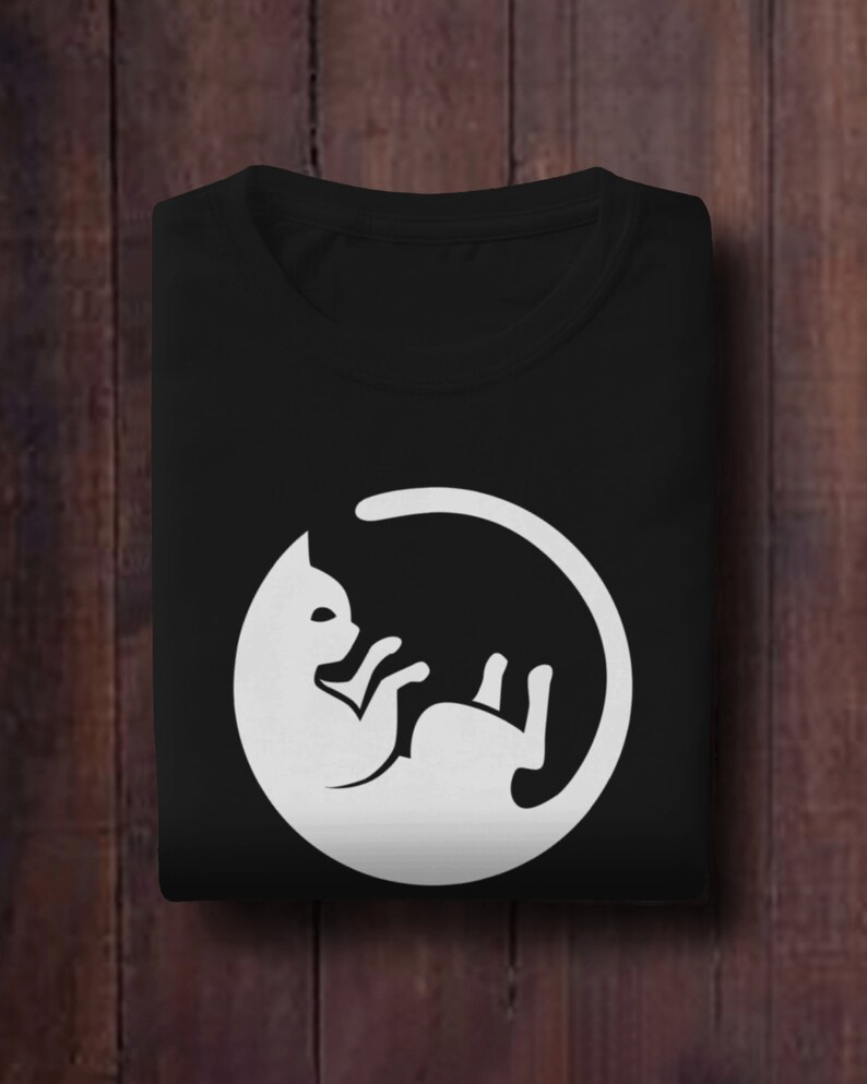 May include: Black t-shirt with a white graphic of a cat curled up in a circle.