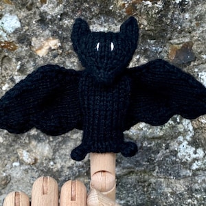 May include: Black knitted bat finger puppet with white eyes.