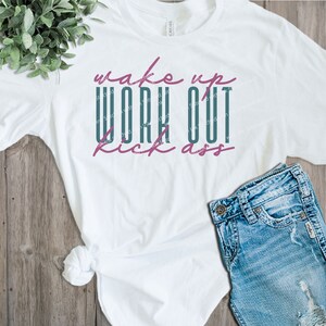 May include: White t-shirt with the text "Wake up Work Out Kick Ass" in teal and pink lettering.