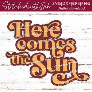 May include: A digital download of a graphic design featuring the text "Here comes the sun" in a retro style with orange and brown lettering. The text is surrounded by a white background with a wood grain texture.