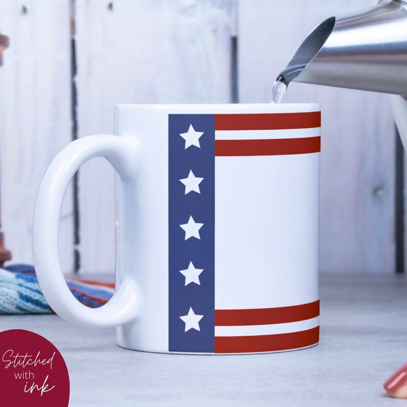 K&ouml;nnte beinhalten: Wei&szlig;e Keramiktasse mit einem amerikanischen Flaggenmuster in Blau und Rot. Die Tasse hat ein wei&szlig;es Innenleben und einen gro&szlig;en Henkel.