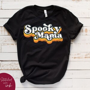 May include: Black t-shirt with a retro-style orange and yellow graphic that says "Spooky Mama".