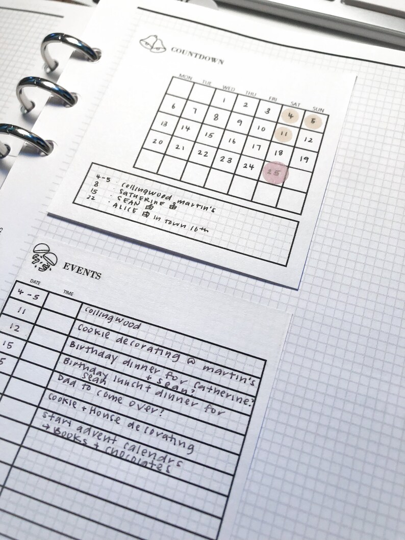 Puede incluir: Una p&aacute;gina de calendario con una cuenta atr&aacute;s hasta una fecha marcada con un c&iacute;rculo rosa. La fecha es el 25. El calendario se titula "Cuenta atr&aacute;s" y los d&iacute;as de la semana est&aacute;n listados en la parte superior. Debajo del calendario hay una lista de eventos con fechas y horas. Los eventos incluyen "Collingwood cookie decorating @ Martin's", "Birthday dinner for Catherine", "Birthday lunch + dinner for Sean", "Dad to come over", "Cookie + House decorating", y "Start Advent calendars + books + chocolates".