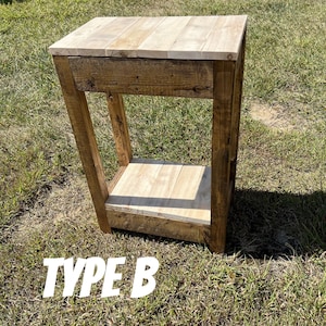 May include: A rustic wooden end table with a single drawer and a lower shelf. The table is stained in a dark brown colour and has a natural wood finish. The table is labelled "TYPE B".