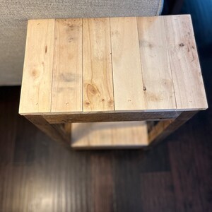 May include: A wooden side table with a natural wood finish. The table has a single shelf and is made of reclaimed wood.
