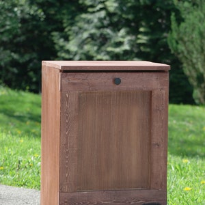 May include: A wooden storage cabinet with a single door and two drawers. The cabinet is stained a dark brown color and has black metal hardware.