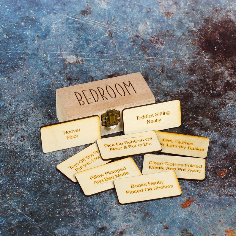 Wooden storage box with household tasks engraved in tokens.