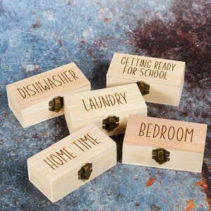 Wooden engraved storage boxes for household task tokens.These are engraved with Dishwasher, Hometime, Bedroom, Laundry and Getting ready for school.