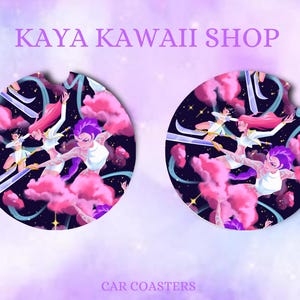 May include: Two car coasters with a fantasy illustration. The coasters feature a design of figures with pink hair and purple hair, set against a backdrop of pink clouds and a starry night sky. The text "KAYA KAWAII SHOP" and "CAR COASTERS" are also visible.