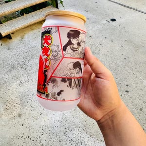 May include: A frosted glass container with a wooden lid featuring a collage of black and white manga illustrations with red accents. The container has the Japanese text "Inuyasha" on the side.