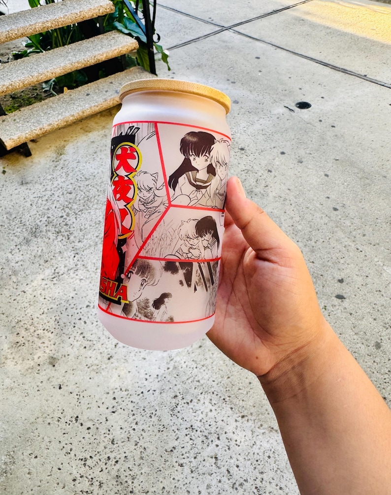 May include: A frosted glass container with a wooden lid featuring a collage of black and white manga illustrations with red accents. The container has the Japanese text "Inuyasha" on the side.