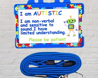 Puede incluir: Lanyard azul con un porta-tarjeta de identificación de plástico azul. La tarjeta tiene un fondo blanco con el texto "Soy AUTISTA. Soy no verbal y sensible al sonido. Tengo una comprensión limitada. Por favor, ten paciencia." y un robot de dibujos animados.