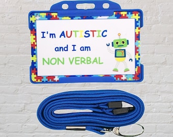Puede incluir: Lanyard azul con un porta-tarjetas de identificación de plástico azul. La tarjeta tiene un fondo blanco con piezas de rompecabezas de colores alrededor del borde. El texto en la tarjeta dice "I'm AUTISTIC and I am NON VERBAL". Un robot de dibujos animados está en el lado derecho de la tarjeta.