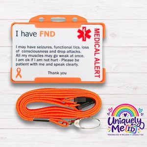 May include: An orange plastic ID card holder containing a white card with the text I have FND, a red medical symbol, and a list of symptoms. An orange lanyard with a metal clip is positioned below the card holder.