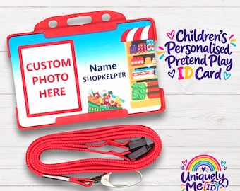 May include: A red plastic ID card holder containing a personalized pretend play card with a grocery store theme, featuring a space for a custom photo and the text Name SHOPKEEPER, accompanied by a matching red lanyard with a metal swivel hook.