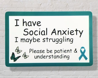 May include: Teal blue rectangle with rounded corners and white background. The text reads "I have Social Anxiety I maybe struggling Please be patient & understanding". There are three butterfly images and a teal blue ribbon.