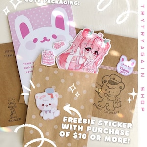May include: An assortment of cute packaging items, including stickers, cards, and brown paper bags. The stickers feature anime-style characters, a bear, and a bunny. Text includes "Cute Packaging!" and "Freebie Sticker with Purchase of $10 or More!"
