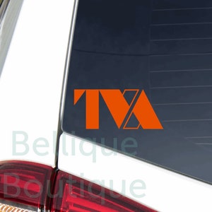 May include: Orange vinyl decal with the letters "TVA" on a white car.