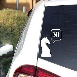 May include: A white vinyl decal applied to a car window featuring a silhouette of a chess knight piece. A speech bubble extends from the knight containing the text NI in white capital letters against a black background within the bubble outline.