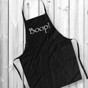 May include: Black apron with a white pocket and the word "Boop!" printed on the front.