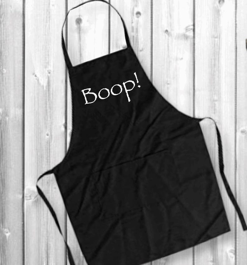 May include: Black apron with a white pocket and the word "Boop!" printed on the front.