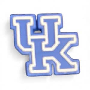 May include: A blue and white charm featuring the interlocking letters "UK". The letters are in a bold, block style with a white outline. The charm is likely made of a hard material and is designed to be attached to a shoe or accessory.