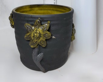 Vase de poterie en céramique fait à la main décoratif noir et jaune moyen avec des fleurs surélevées sculptées texturées sur de l'argile noire