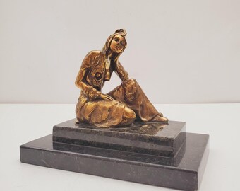 大理石の台座に座るブロンズの女性像 - ドレスを着た優雅な女性像