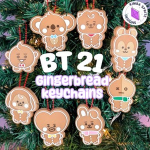 May include: A collection of eight brown gingerbread-style character keychains featuring various BT21 designs with red beaded chains. The text BT21 Gingerbread keychains is displayed in the center, with a Kimba Sprite Designs logo in the corner.