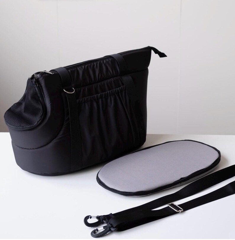 Puede incluir: Bolsa de transporte para mascotas negra con una ventana de malla, un coj&iacute;n gris extra&iacute;ble y una correa de hombro ajustable.