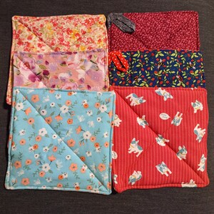 May include: Set of six colourful quilted pot holders. The pot holders feature various patterns including floral, polka dot and geometric designs.