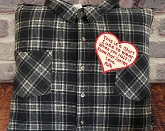 May include: A black and white plaid pillow with a red heart-shaped patch that says "This is a Shirt I use to wear When you Hold it Know that I am Here, Love. Papa".