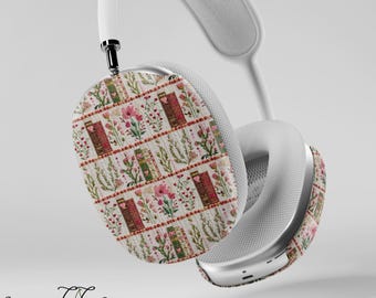 May include: White wireless headphones with a custom skin featuring a repeating pattern of pink flowers, green leaves, and red and green books. The skin is called "Cherry Charms Cases".