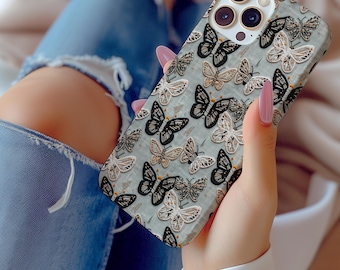 May include: A phone case with a white background and a pattern of black and gold butterflies. The case has a camera lens cutout and a raised lip around the edges.