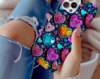May include: A black phone case with a colorful heart design. The hearts are covered in rhinestones and glitter. The case has a camera cutout and a raised lip around the edges.