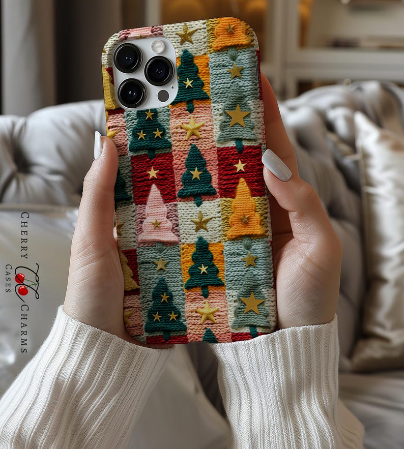 Op de afbeelding: Een telefoonhoesje met een kerstboompatroon. Het hoesje is gemaakt van gebreid materiaal in verschillende kleuren, waaronder rood, groen, blauw en geel. Het hoesje heeft een herhalend patroon van kerstbomen en sterren.