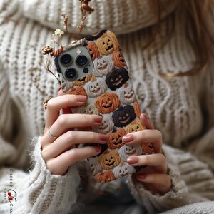 Puede incluir: Una funda para tel&eacute;fono con un patr&oacute;n de caras de calabaza naranja y negra. La funda est&aacute; hecha de un material duradero y est&aacute; dise&ntilde;ada para proteger tu tel&eacute;fono de ara&ntilde;azos y golpes.