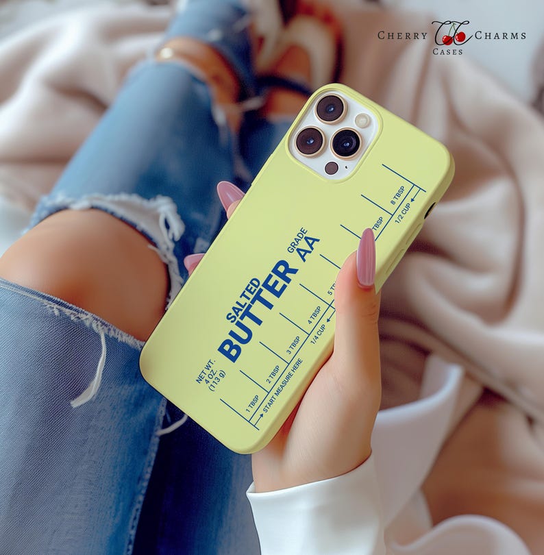 May include: A yellow iPhone case with a stick of salted butter printed on it. The case has a measurement guide for tablespoons and cups. The text on the case reads "Salted Butter AA" and "Net Wt. 4 oz (113 g)".